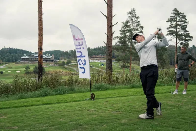 Golfer teeing off at an nShift golf event