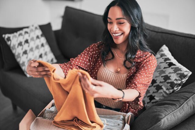 small-SINGLE-IMAGE_delighted-mixed-race-woman-checking-online-delivery-clothes_july25