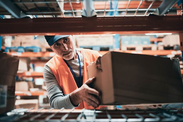 small-SINGLE-IMAGE_mature-male-warehouse-worker-placing-box-on-shelf-rack-full-colour_july25