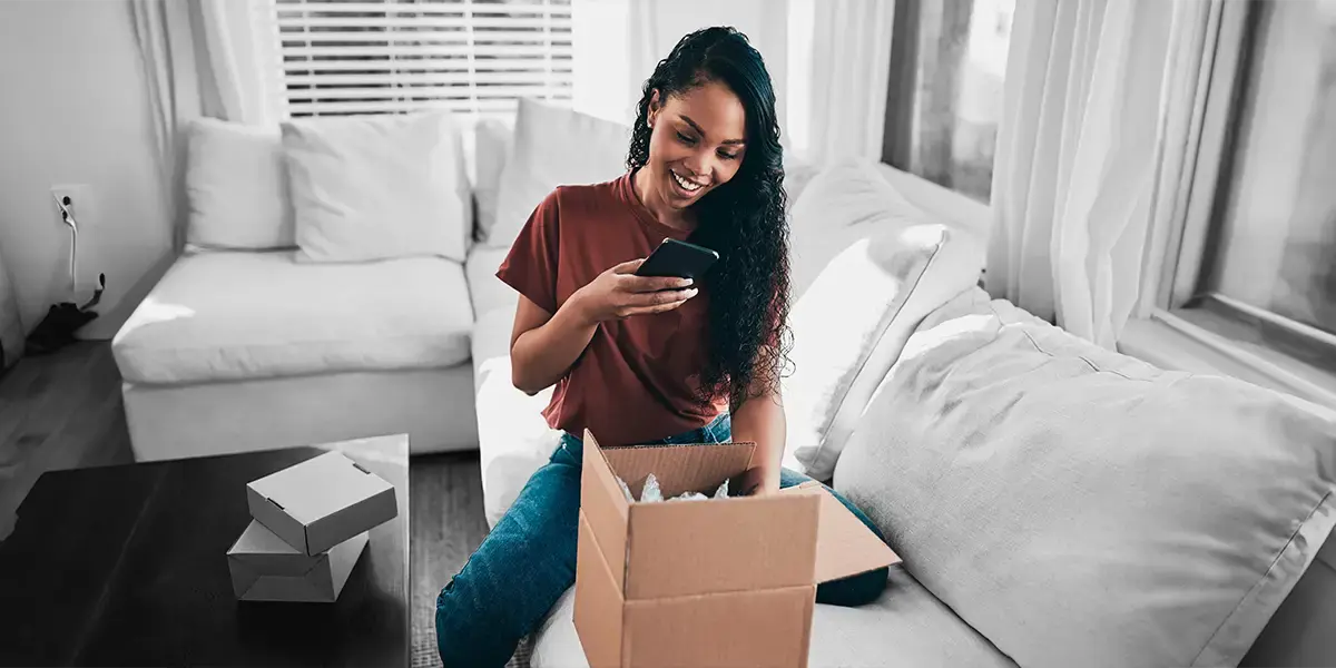A woman delighted with the delivery of her parcl. Set in a lounge setting